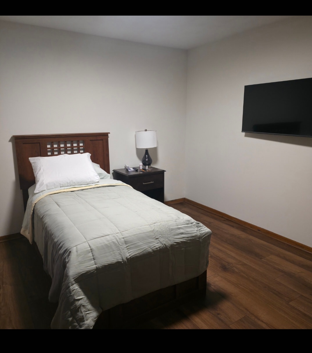Bedroom with wall-mounted TV at Floxy AbilityNest
