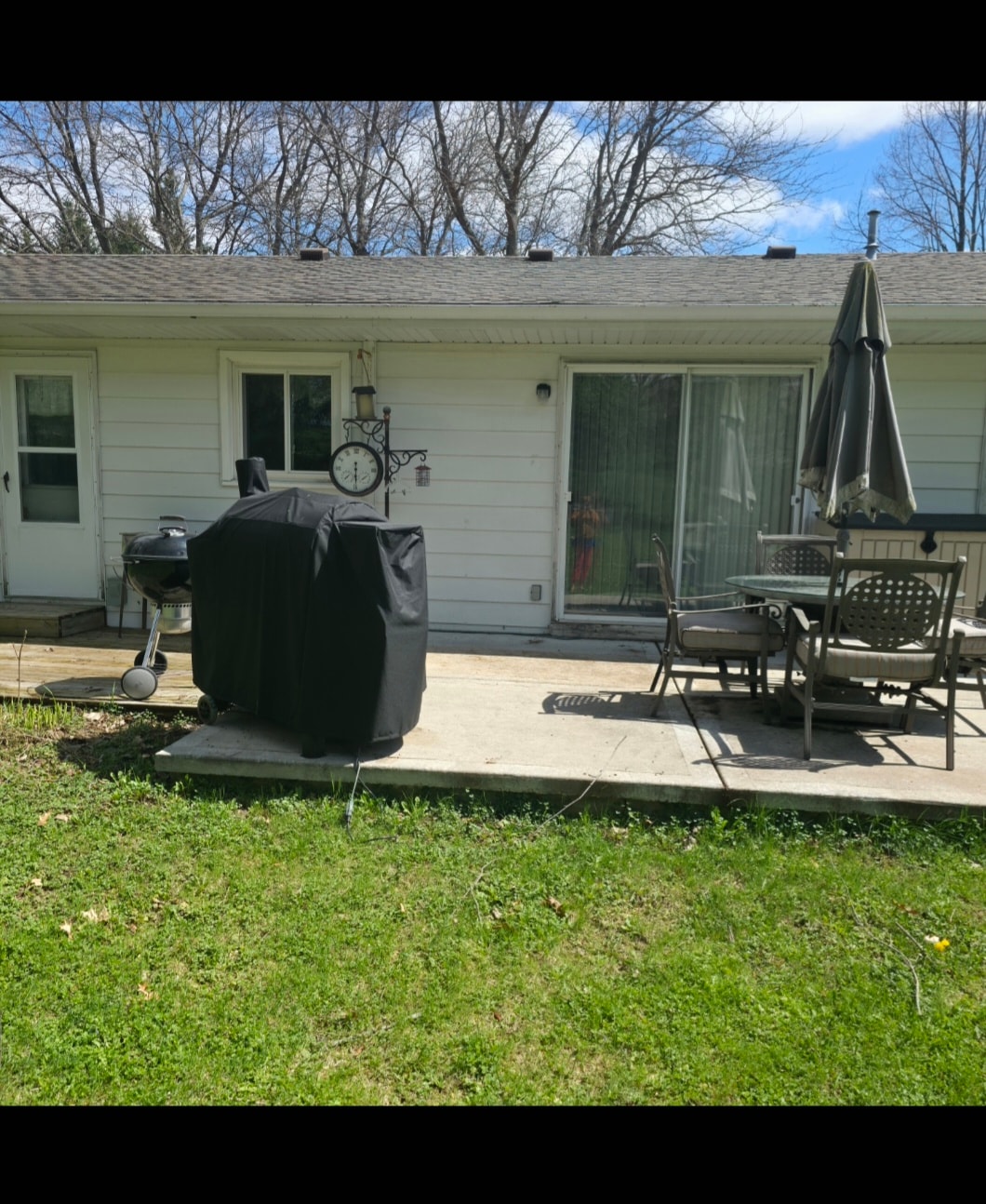 Backyard patio with grill and umbrella at Floxy AbilityNest